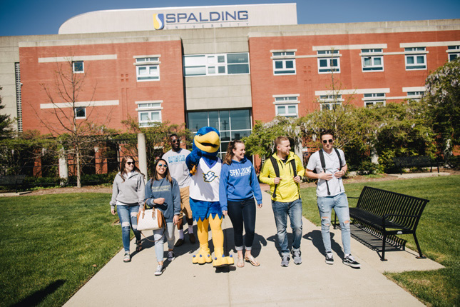 Students walk with Ollie mascot on campus