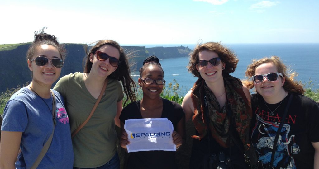 Student pose with Spalding University flag during Ireland study abroad experience